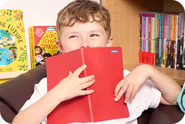kleine jongen die een boek vasthoudt met een ministicker-label erop
